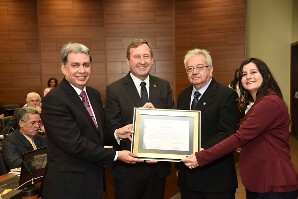 Francisco Almeida (D) recebe das mãos de Joel Krüger, Ricardo Veiga e Ana Renata Litfalla (E), homenagem por suas contribuições à construção da história do Crea-GO