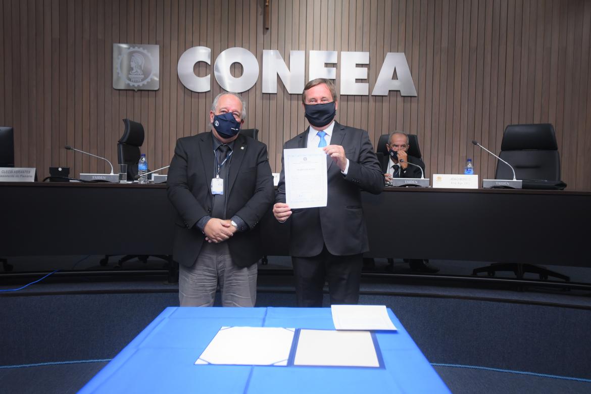 O vice-presidente no exercício da presidência, eng. civ. Osmar Barros Júnior, assinou e entregou o termo de posse ao presidente reeleito
